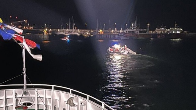 rescue teams aid sailboat